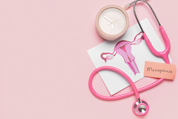 Papers with word MENOPAUSE, uterus, stethoscope and alarm clock on pink background - obrazy, fototapety, plakaty