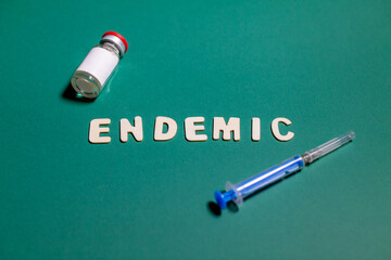 endemic sign on green background with vaccine and syringe