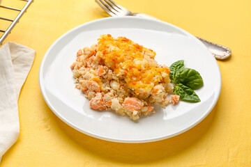Plate with tasty English fish pie on yellow background