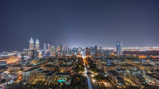 Panorama of skyscrapers in Barsha Heights district and low rise buildings in Greens district aerial night timelapse.