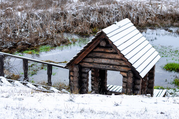 wooden font with a cross in the snow