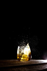 salpicadura de agua con cubitos de hielo en vaso de vidrio