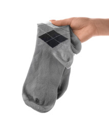 Woman holding pair of socks on white background