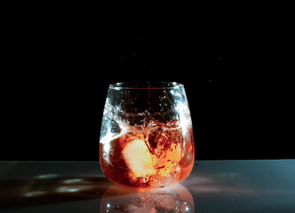 salpicadura de agua con cubitos de hielo en vaso de vidrio
