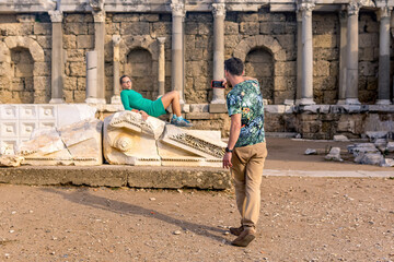 couple of tourists take pictures of each other among the ancient ruins