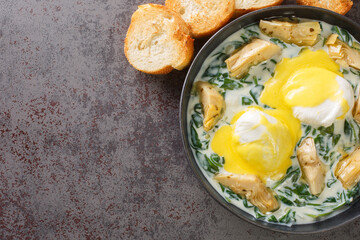 New Orleans Style Eggs Sardou Poached Eggs With Artichoke, Spinach and Hollandaise close up in the...