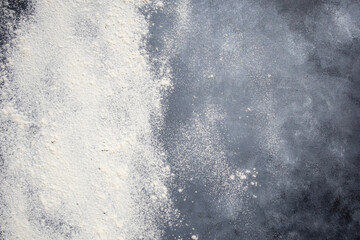 Flour is scattered on a dark background, space for text.