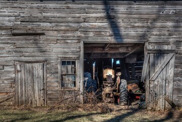 Fototapeta na wymiar Old wooden barn with tractor