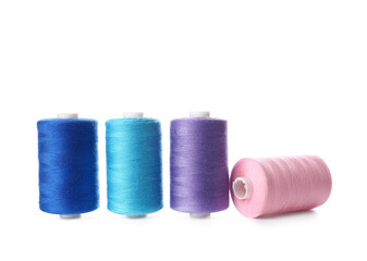 Different sewing thread spools on white background