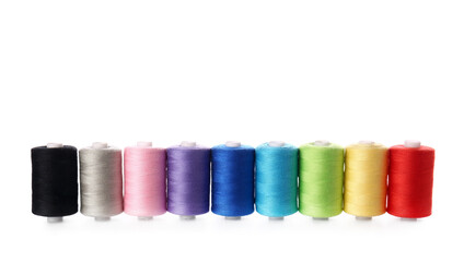 Different sewing thread spools on white background