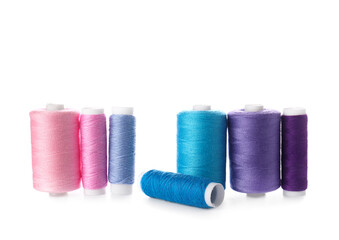 Different sewing thread spools on white background
