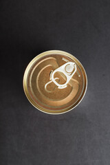 The lid of a metal tin can on a black background