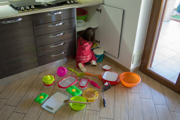 adorable little girl playing in the kitchen and messing everything up