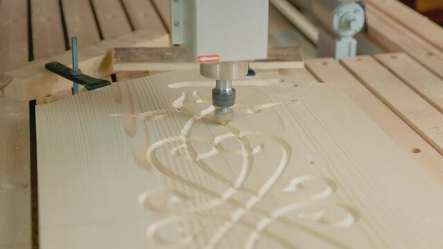 CNC machine cuts a pattern on a piece of wood