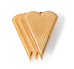 Three heart shaped wafers for garnishing isolated on a white background. Thin flat waffle biscuits for ice cream decoration. Macro. Baked wheat pastry for Valentine day food design.