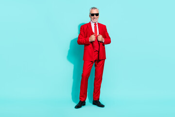 Photo of confident man pensioner dressed red three piece tux dark glasses walking isolated teal color background