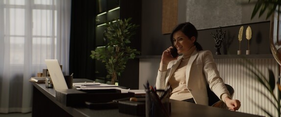 CU Portrait of Caucasian female businesswoman talking on the phone in her office or at home