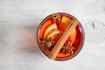 glass with mulled wine, lemon on wooden background