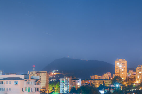 Star Trails Over The City In Mountains