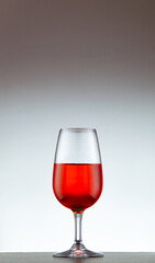 copa de vino tinto sobre un fondo blanco
