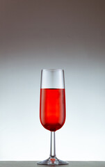 copa de vino tinto sobre un fondo blanco
