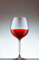 copa de vino tinto sobre un fondo blanco
