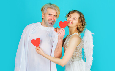 Smiling Valentines couple with paper hearts. Angels with white wings. Love. Relationships.
