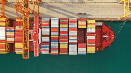 Aerial drone top down photo of anchored container ship in loading - unloading logistics terminal