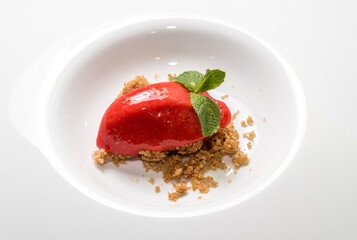 Homemade Organic Berry Sorbet Ice Cream Quenelle Shaped with Mint Leaves on Crumbled Cookie