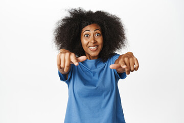 Its you, congratulations. Amazed african american woman points fingers at camera and smiles...