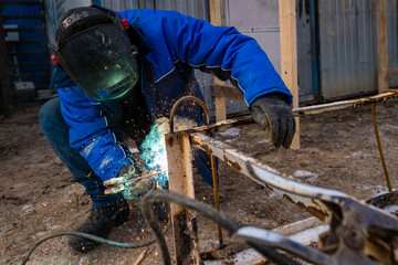 a masked welder does his job, a welder cooks metal