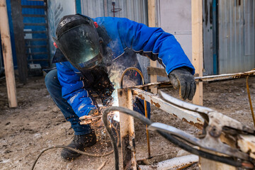 a masked welder does his job, a welder cooks metal