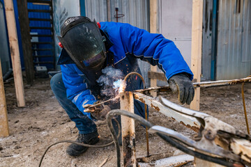 a masked welder does his job, a welder cooks metal