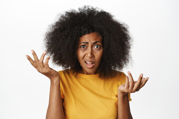 Portrait of confused Black woman looking puzzled and annoyed, cant understand smth strange, freak out, standing over white background - obrazy, fototapety, plakaty