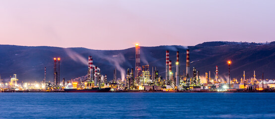 Petroleum Refinery Plant with sunset landscape. Refinery on coast. Oil industry.