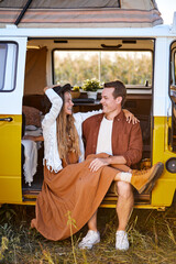Caucasian Couple Sit Outdoors On Van For Travel, Relaxing, Laughing, Alternative Travel For Family Couple, Casually Dressed, Enjoying The Outdoor Leisure Activity and Wanderlust Life