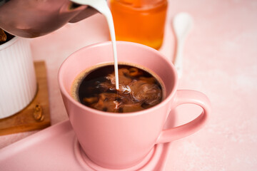 Coffee americano with milk in cup and saucer isolated on a white background.