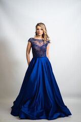 beautiful young blond woman in dress on white studio background