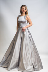beautiful young blond woman in dress on white studio background