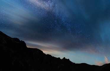 Beautiful long exposure dramatic clouds with milky way galaxy. Night starry sky background.