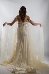 Fototapeta premium Beautiful bride in a magnificent white wedding dress of tulle with corset lacing and long beauty hair