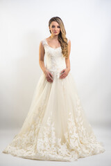 Fototapeta na wymiar Beautiful bride with fashion hairstyle and make-up wearing wedding dress on white background 