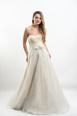 Beautiful bride with fashion hairstyle and make-up wearing wedding dress on white background 