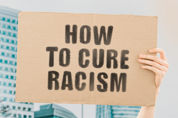 The phrase " How to cure racism " on a banner in men's hand with blurred background. Equality. Human rights. Discrimination. Black lives matter. Peace. Treatment