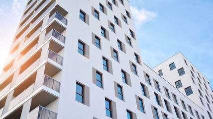 Fototapeta na wymiar Modern luxury residential flat. Modern apartment building on a sunny day. White apartment building with a blue sky. Facade of a modern apartment building.