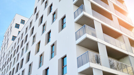 Modern luxury residential flat. Modern apartment building on a sunny day. White apartment building with a blue sky. Facade of a modern apartment building. - obrazy, fototapety, plakaty
