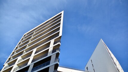 Modern luxury residential flat. Modern apartment building on a sunny day. White apartment building with a blue sky. Facade of a modern apartment building.