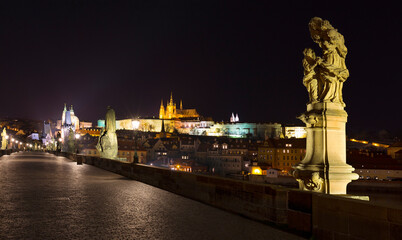 Night winter Prague Lesser Town with the gothic Castle from Charles Bridge above the River Vltava, Czech Republic