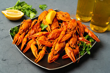 Delicious red boiled crayfish on a gray table, with parsley and lemon. top view