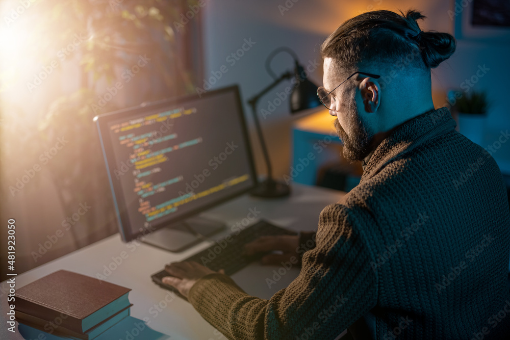 Poster view from shoulder of mature man using desktop pc for writing code late at home. professional progra